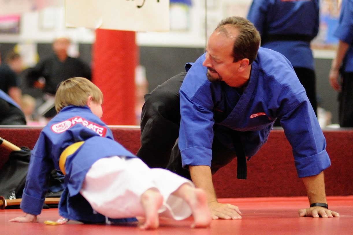 Mile High Karate instructor coaching a young student during push-ups
