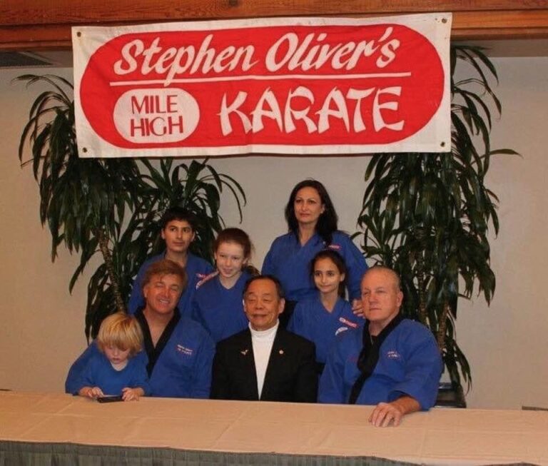 Grand Master Jhoon Rhee with Mile High Karate Black Belts under a Stephen Oliver's Mile High Karate banner at the Black Belt Retreat